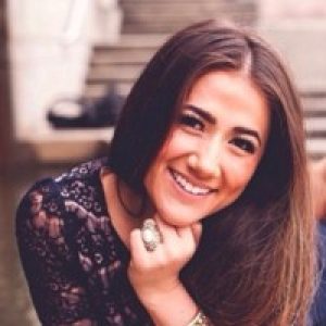 Smiling woman portrait in natural light wearing a black lace top.